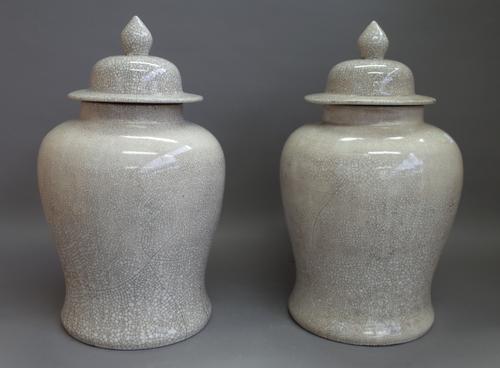 A pair of modern Chinese pottery vases and covers decorated with crackle glaze against a baluster ground, 48cm high. (2)