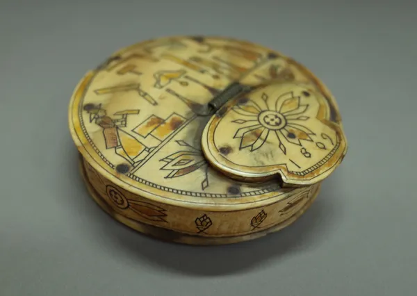 An unusual animal horn circular snuff box dated 1809, coloured and engraved with a couple building a house, 8cm diameter.