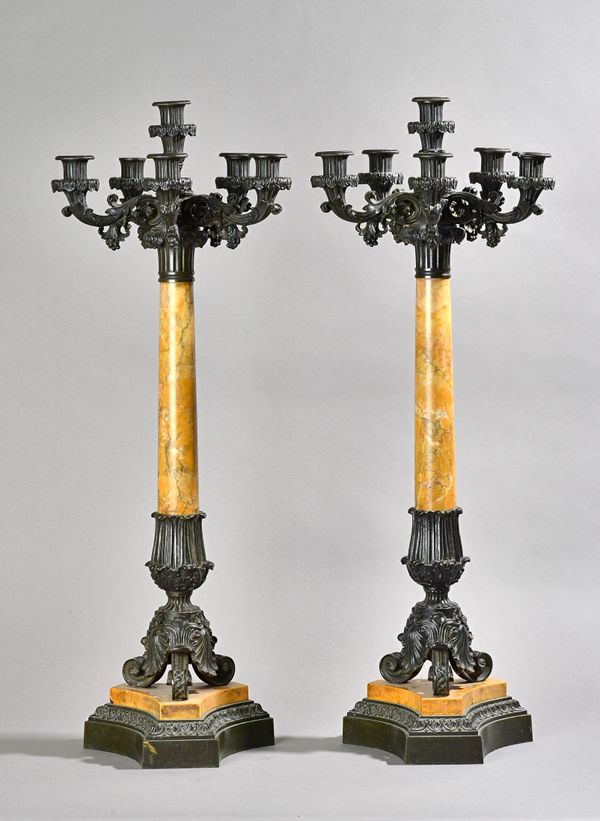 A pair of French marble and bronze mounted six branch candelabra, late 19th century, of scroll column form on a stepped triform base, 74cm high, (a.f.
