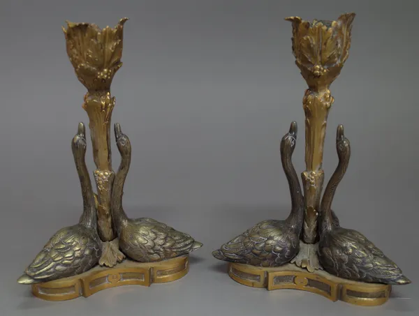 A pair of Regency ormolu candlesticks, circa 1830, after a design by William Bateman for Rundell, Bridge & Rundell, each depicting three swans around