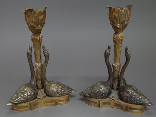 A pair of Regency ormolu candlesticks, circa 1830, after a design by William Bateman for Rundell, Bridge & Rundell, each depicting three swans around