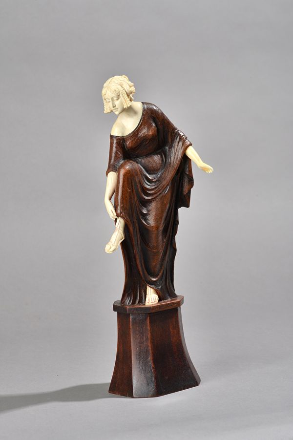 Leonie Boehm-Hennes (German, fl.c.1900-1920) a carved ivory wood sculpture of a female adjusting her sandal, circa 1920, raised on a chamfered base, s
