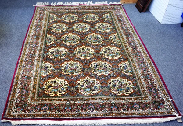 A Kashan carpet, Persian, the brown field with rows of ivory cartouches each bearing floral bouquets, a complementary floral border, 336cm x 234cm.