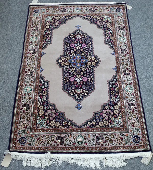 A part silk Kashan rug, Persian, the plain grey field with a floral medallion, matching spandrels, a beige floral spray border, 165cm x 105cm.