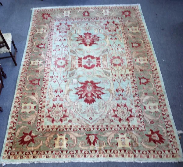 A Heriz carpet, Persian, the pale indigo field with bold madder palmettes and vine design, a complementary palmette and leaf border, 377cm x 274cm.
