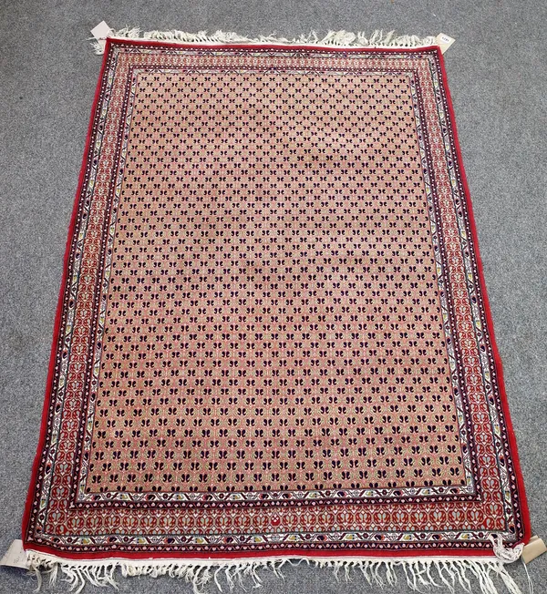 A fine Indian rug, the field with a honeycomb of botehs within a complementary madder border, 153cm x 106cm.