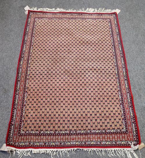 A fine Indian rug, the field with a honeycomb of botehs within a complementary madder border, 153cm x 106cm.