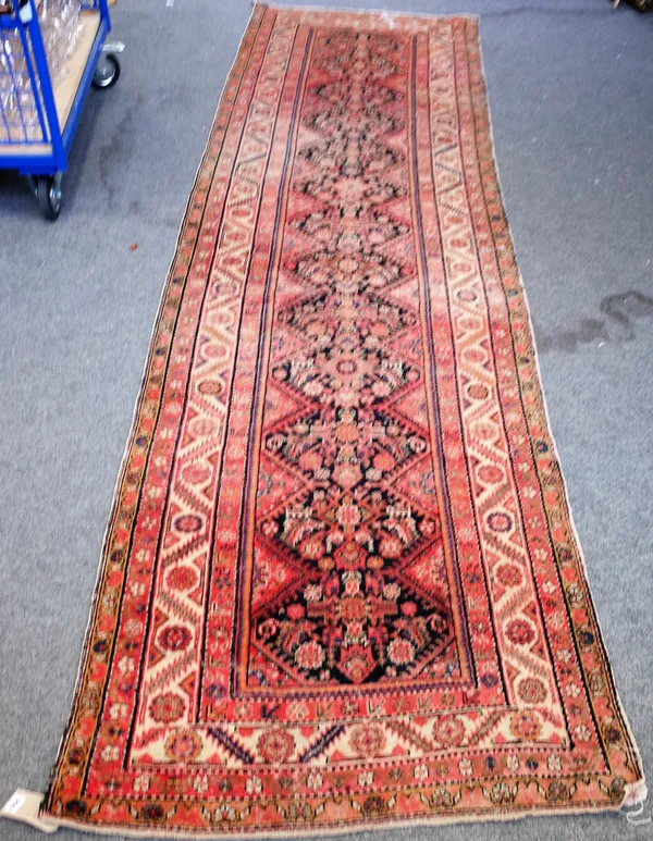 A Feraghan runner, Persian, the shaped black field with a herate pattern, an ivory rosette and leaf border, 411cm x 112cm.