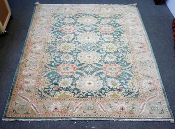 A modern Egyptian carpet, the sage field with an overall bold floral design, a beige palmette and leaf border, 290cm x 258cm.
