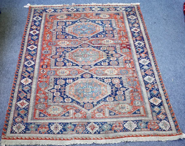 An antique Soumac carpet, possibly South Caucasian, the madder field with three bold medallions supporting motifs; an indigo diamond and boteh border,