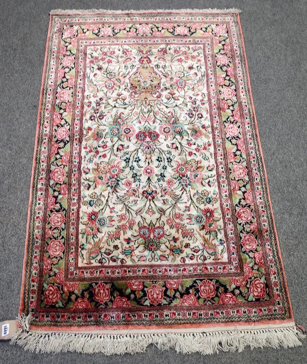 A small Persian part silk rug, white ground with bird and floral decoration around a vase, 131cm x 79cm.