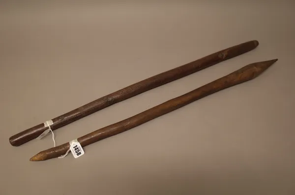 An Australian Aboriginal hardwood club with bulbous tapering end and a crudely carved grip, (72cm) and one further club or digging stick with carved g