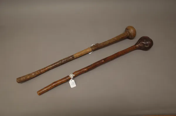 An East African hardwood club, with bulbous head and central leather grip (66cm) and another similar East African club, (2).