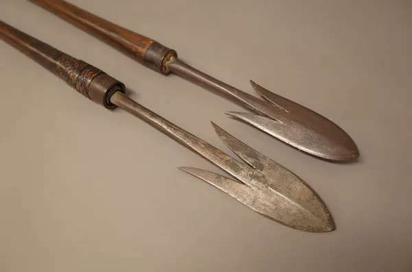Two Northern Philippines Igorot spears, each with barbed iron tips and wooden tapering shaft with iron spike to the opposing end (155cm), (2).