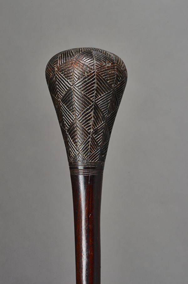An Angolan Chokwe hardwood club, the bulbous head with incised geometric pattern decoration, over a slender tapering shaft, 54cm. Illustrated