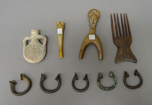 African and other tribal items, including; a figural carved wooden catapult (17cm), a carved wooden comb, a bone corer (13cm), five iron Manilla and s