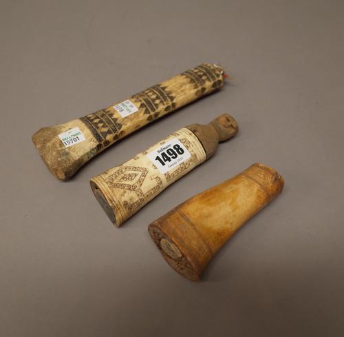 An Inuit caved bone container, with carved wooden figural stopper (13.5cm), another carved bone with beadwork soft pad to one end (18.5cm) and one fur