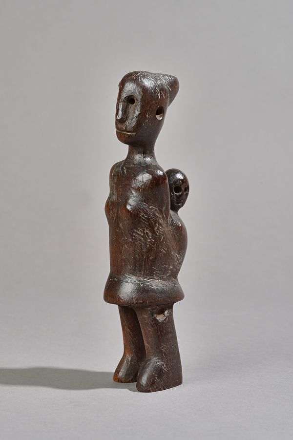 An African tribal hardwood maternity figure, carved with mother carrying a child on her back, 21.5cm high. Illustrated