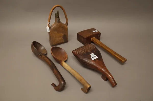 An unusual African hardwood combing tool (30cm), two wooden ladles, a wooden mallet and a leather and brass mounted shot container, (5).