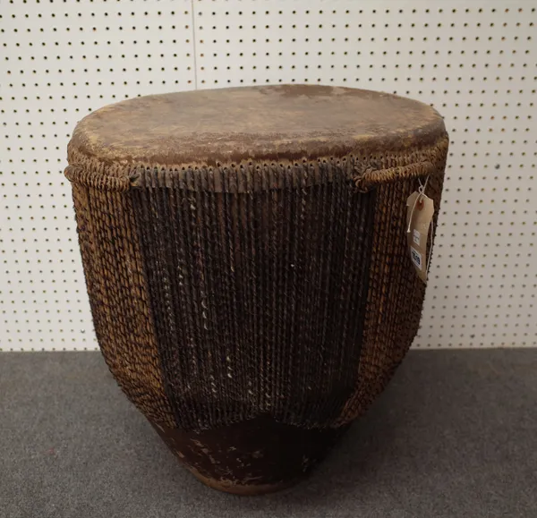 An African tribal drum or large proportions with leather hide and hair decoration to the circular body. 62cm high, 54cm diameter.