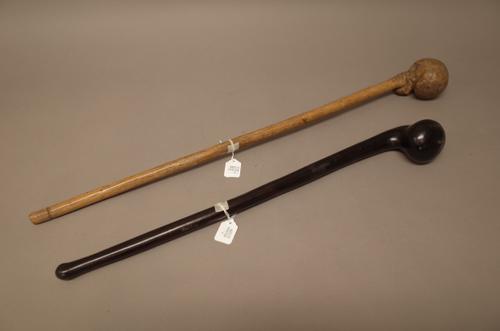 Two East African hardwood clubs, one with naturalistic root form head, 71cm, the other darker with a spherical head, 57.5cm, (2).