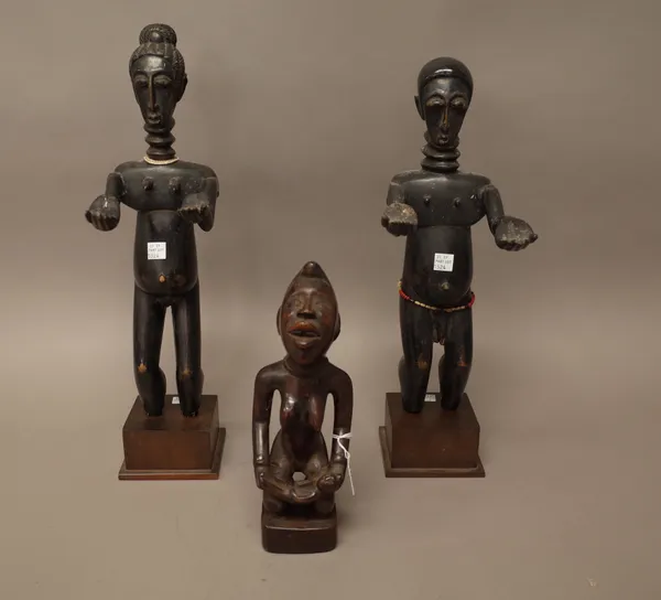 A Congo hardwood carved fertility figure modelled as mother and child, 26cm and a pair of West African ebonised carved wooden figures on wooden plinth