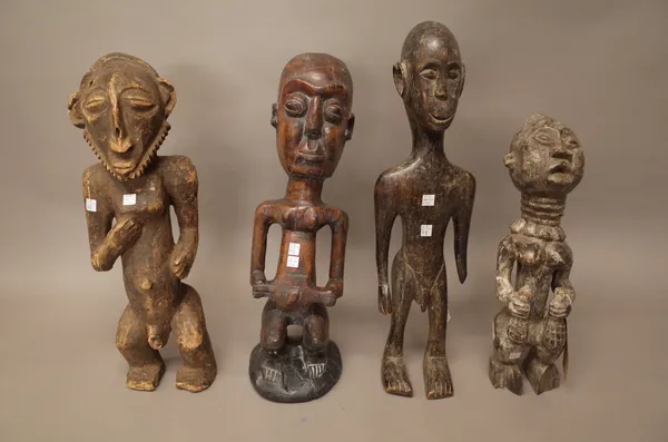 A West African hardwood figure carved carrying two flasks, 43cm high and three further African carved wooden figures, (4).