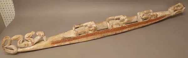 A Maori Waka Taua (war canoe) softwood carved with oarsmen, traces of red and white pigment, 153cm.