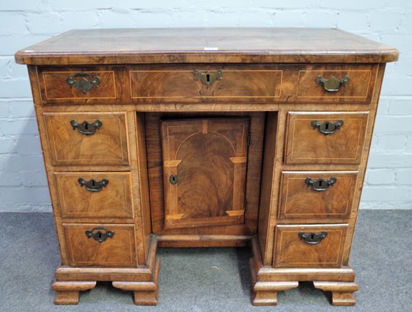 A mid-18th century walnut kneehole writing desk with seven drawers about the recessed cupboard, 92cm wide x 77cm high.