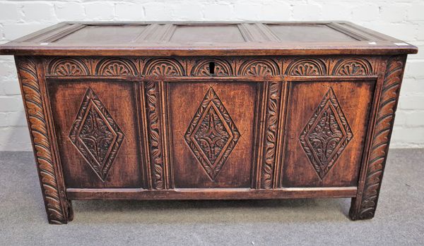 A 17th century and later oak coffer with triple panel lid and later carved front 112cm wide x 61cm high.