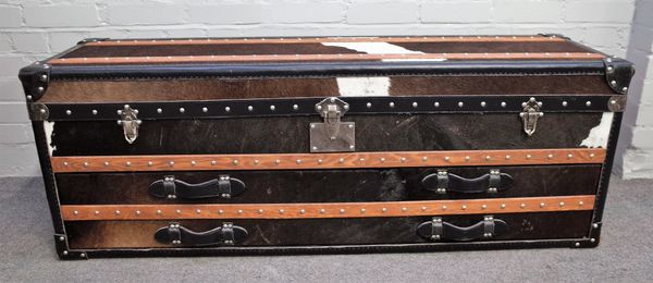 A 20th century cow hide and leather upholstered travelling trunk, with fitted interior for shoes etc., 141cm wide x 50cm high.