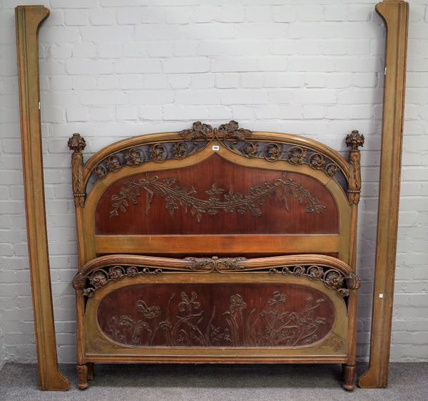 An Art Nouveau green stained and foliate carved double bed, 146cm wide x 140cm high.  56