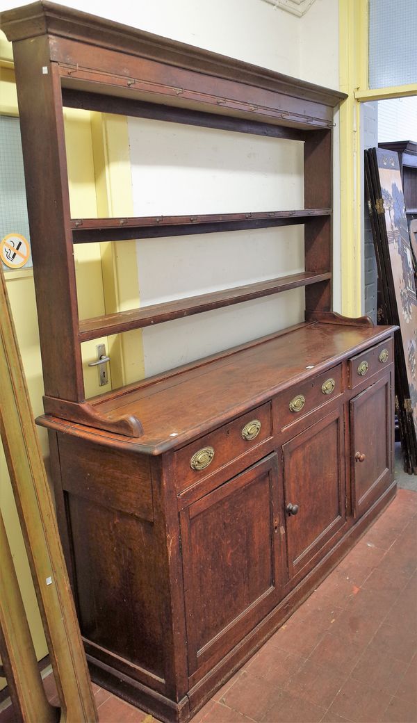 A mid-18th century oak dresser, with open three tier plate rack over three drawers and three cupboards, 165cm wide x 209cm high.