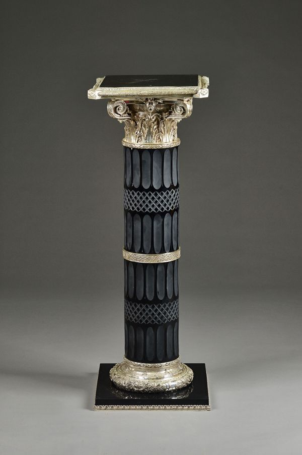 A 20th century polished steel and cut glass column, with square top and Ionic capital, 41cm wide x 115cm high. Illustrated