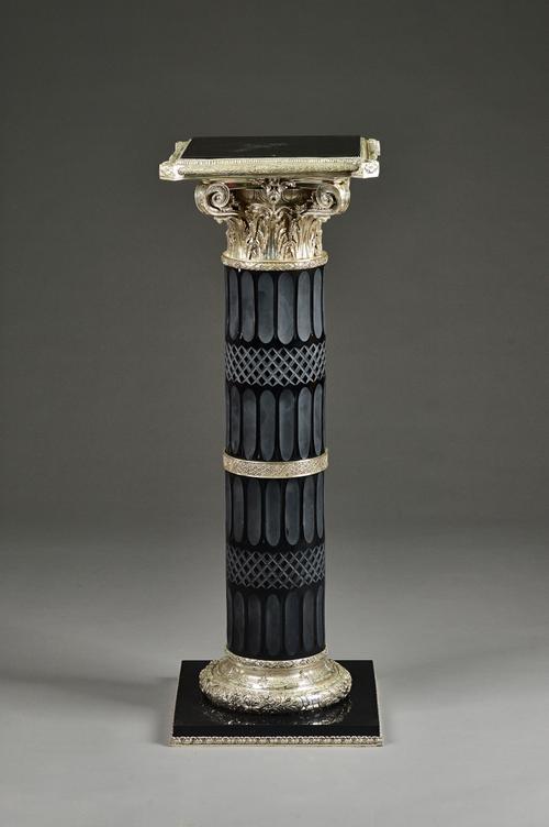 A 20th century polished steel and cut glass column, with square top and Ionic capital, 41cm wide x 115cm high. Illustrated