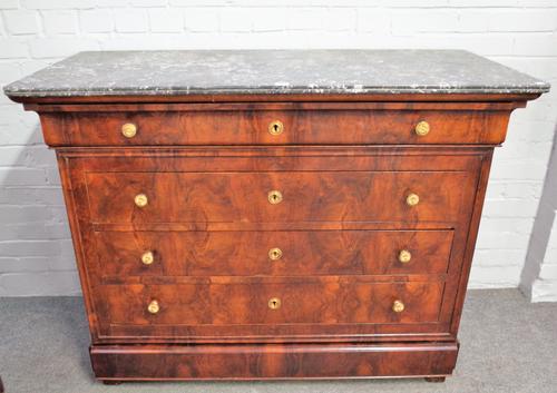 An early 19th century French commode, the marble top over a figured walnut base of five long graduated drawers, 130cm wide x 100cm high.