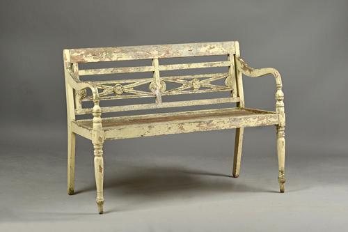 A 20th century distressed white painted teak garden bench with lattice back on turned supports, 118cm wide x 86cm high.  Illustrated