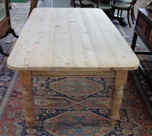 A Victorian pine plank top kitchen table on turned supports, 101cm wide x 173cm long.