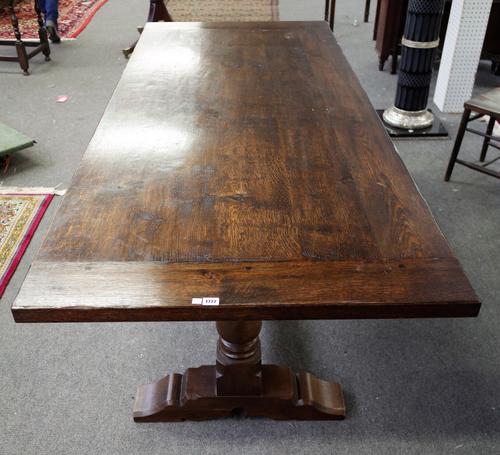 A 17th century style oak refectory table, on a pair of baluster columns united by stretcher, 90cm wide x 229cm long.
