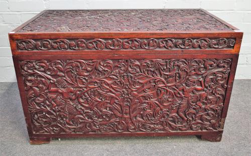 A 19th century Indian teak rectangular lift top trunk with profusely carved decoration, 91cm wide x 55cm high.