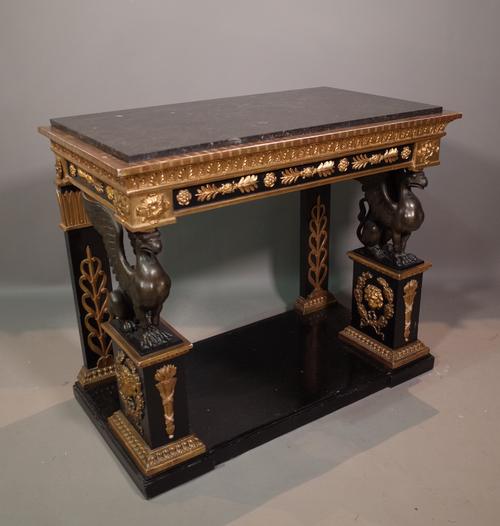 After Percier and Fontaine, an Empire single marble top ebonised parcel gilt console on griffin supports, 93cm wide x 78cm high.  Illustrated