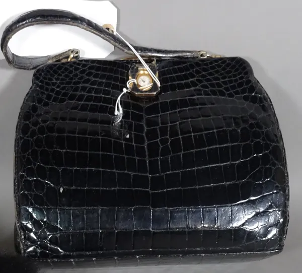 A black leather patent faux crocodile skin handbag, with single handle and gilt fittings, the clasp with inset Mortima timepiece.  CAB