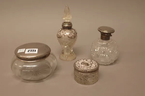 A small group of silver mounted glassware, comprising; a powder bowl, Birmingham 1921, a toilet jar, Birmingham 1909 and two scent bottles, London 191