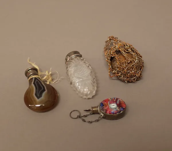 A Victorian silver hinge lidded agate scent bottle, of drop shaped form, a silver hinge lidded faceted glass scent bottle of oval form and two further