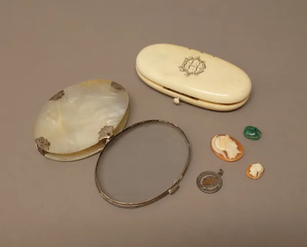 A silver mounted mother-of-pearl oval magnifying glass, probably circa 1800, an ivory cased part sewing necessaire, (the thimble and part of the sciss