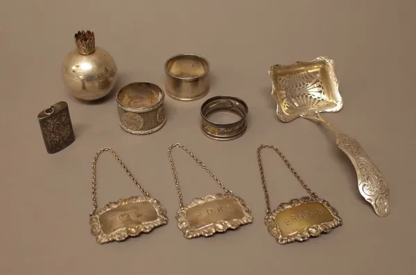 Silver, comprising; two napkin rings, a Victorian table lighter, of spherical grenade form (loaded), a curved rectangular vesta case, with foliate eng