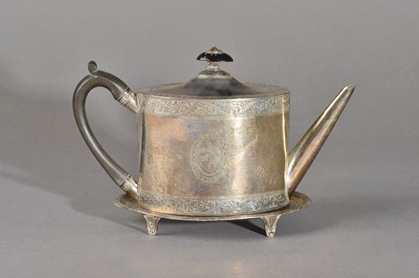 A George III silver teapot, of oval form, the body engraved with a shield and a motto, within feathered scroll engraved bands, with a tapering spout a