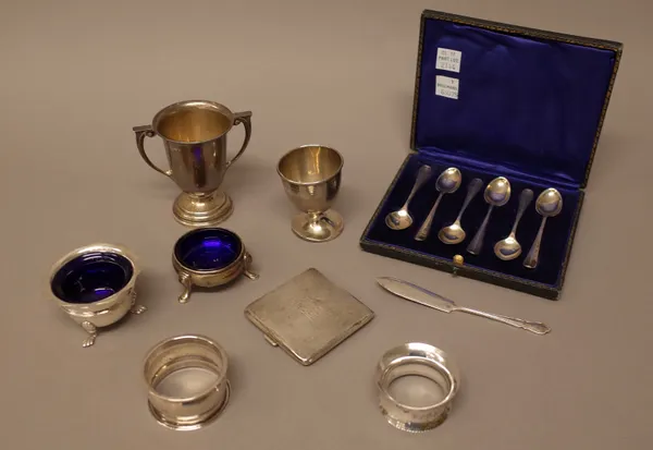 Silver, comprising; a set of six coffee spoons, with a case, a twin handled trophy cup, an egg cup, two various salts with blue glass liners, a lady's