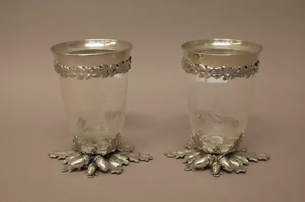 A pair of silver plated metal mounted glass vases, the glass bodies etched with differing views of stags, the plated mounts decorated with acorns and