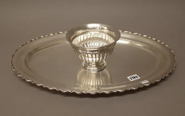 A silver coloured white metal serving dish, of shaped oval form, decorated with a scrolling border, length 49.5cm and a circular pedestal bowl, with p